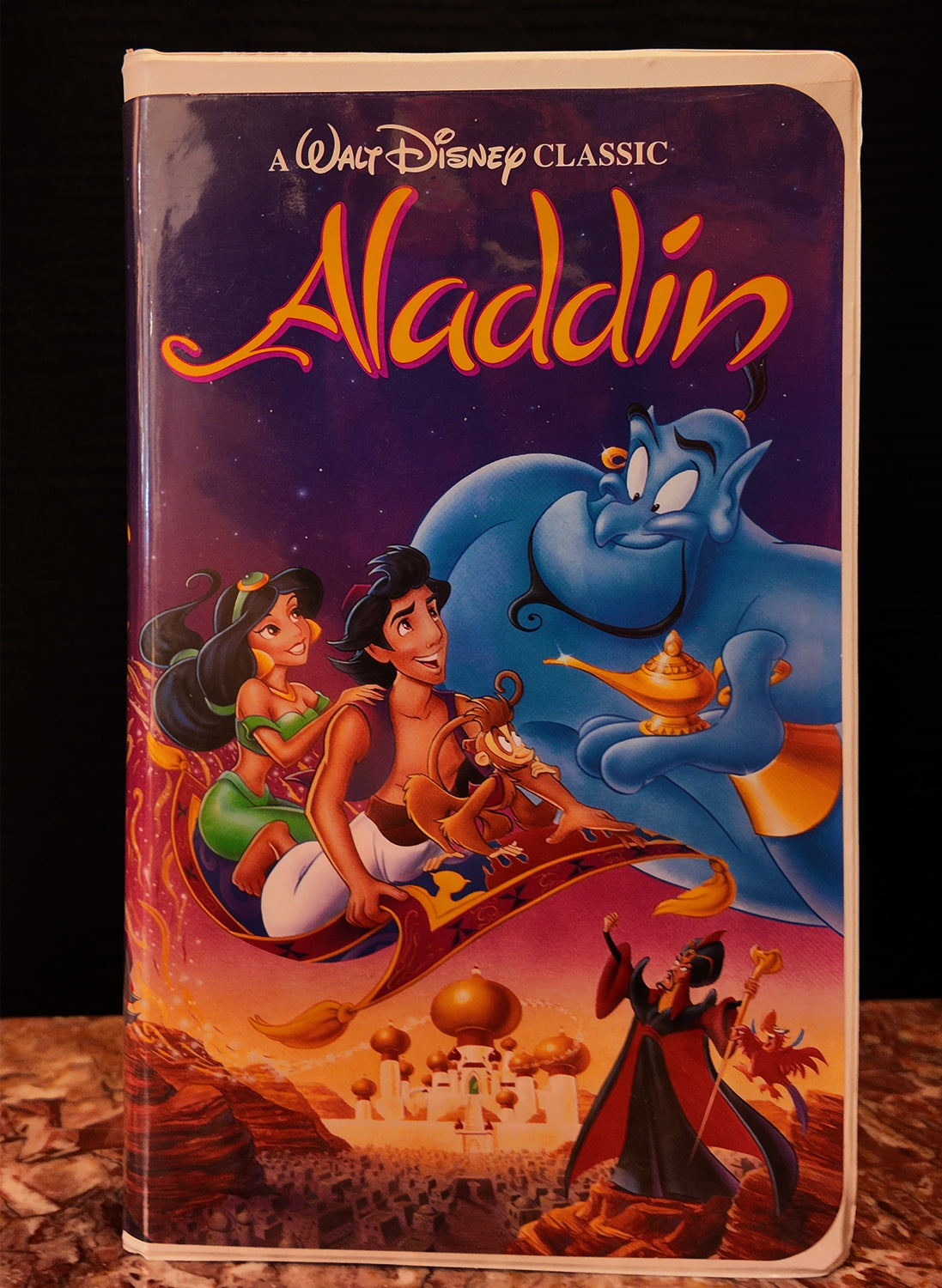 VHS tape cover of 'Aladdin' with characters and genie on a dromedary.