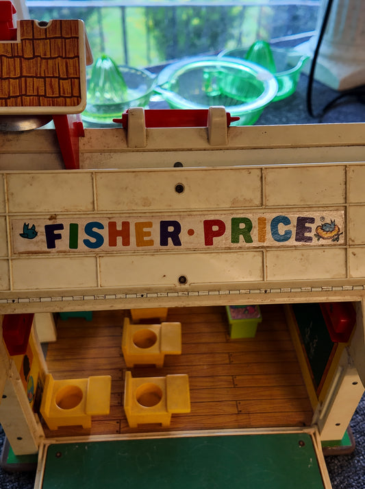 Fisher-Price toy structure with colorful letters spelling 'Fisher-Price' on a blurred background.
