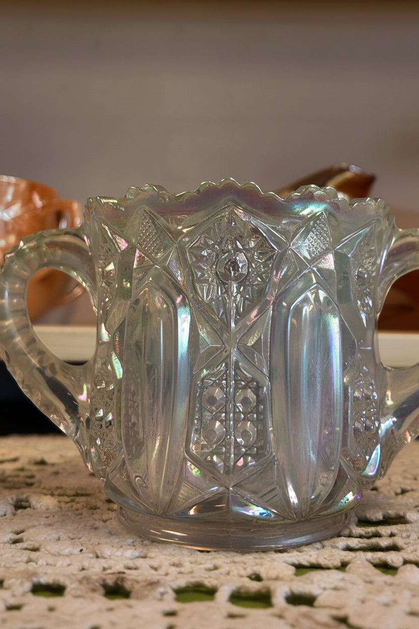 Decorative glass candy dish with intricate patterns on a textured surface.