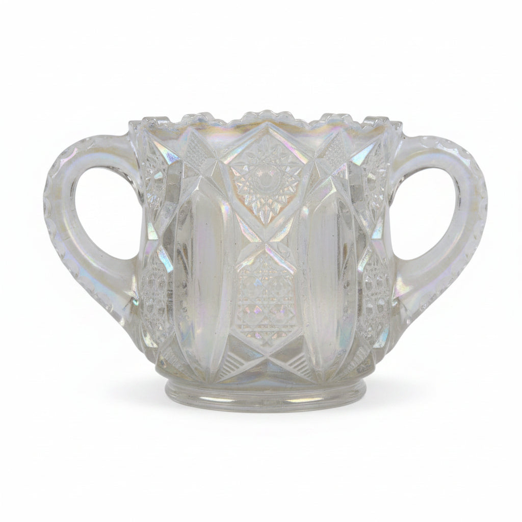 Iridescent glass cup with decorative patterns on a textured surface